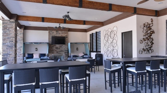 kitchen featuring beam ceiling and an outdoor stone fireplace