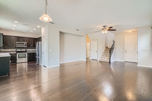 unfurnished living room featuring hardwood / wood-style flooring, ceiling fan, and a textured ceiling