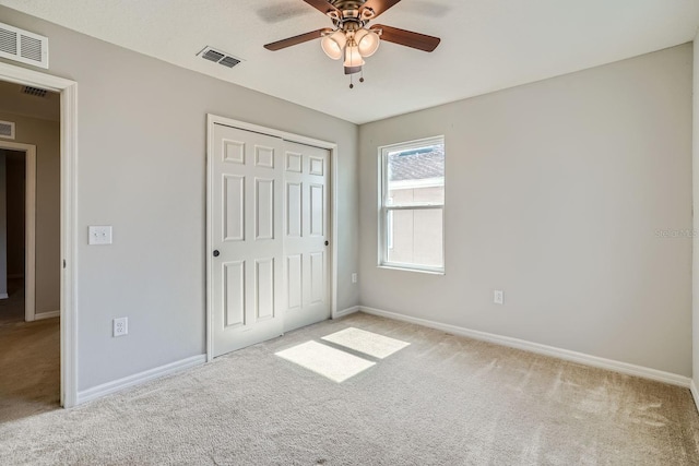 unfurnished bedroom featuring ceiling fan, a closet, and light carpet