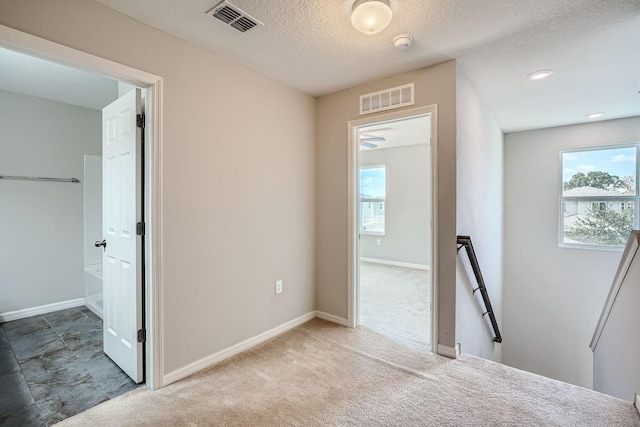 unfurnished bedroom featuring a textured ceiling and light colored carpet