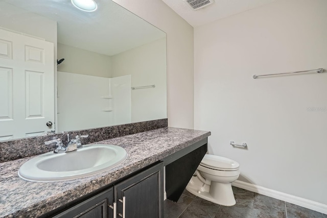 bathroom with tile patterned flooring, vanity, toilet, and a shower