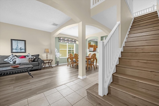 interior space with vaulted ceiling, a textured ceiling, and light hardwood / wood-style flooring