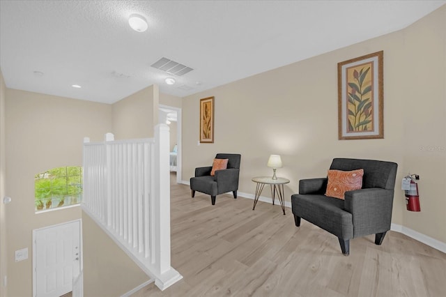 living area featuring light hardwood / wood-style floors and a textured ceiling