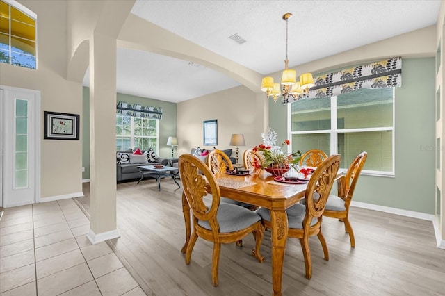 dining space featuring a chandelier, a textured ceiling, and light hardwood / wood-style flooring