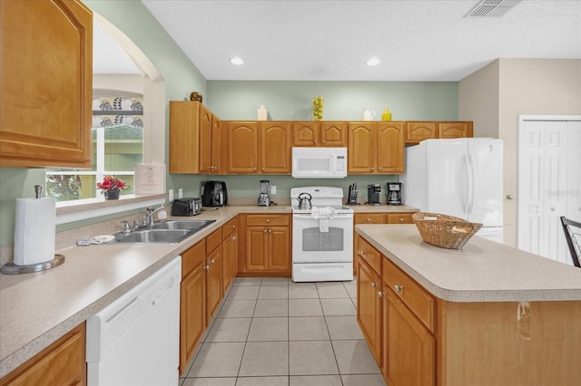 kitchen with sink, a center island, a textured ceiling, white appliances, and light tile patterned floors