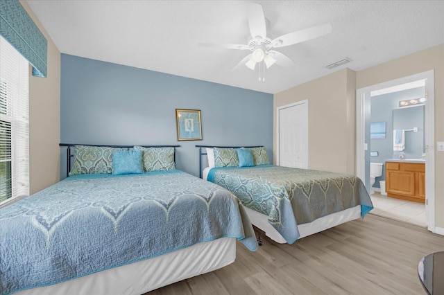 bedroom featuring connected bathroom, light hardwood / wood-style flooring, and ceiling fan