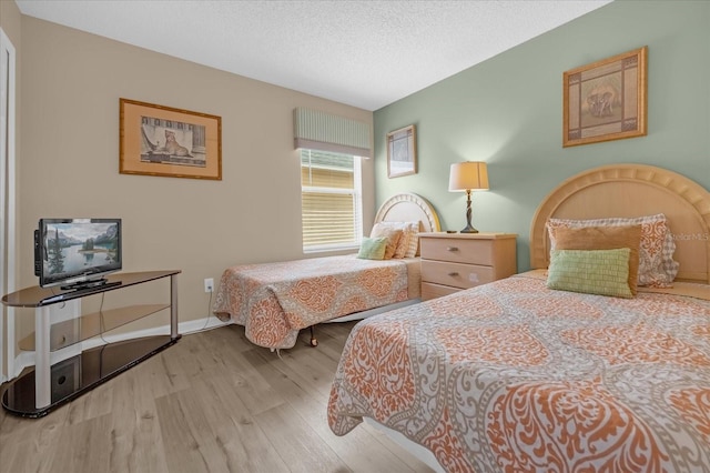 bedroom featuring light hardwood / wood-style floors and a textured ceiling