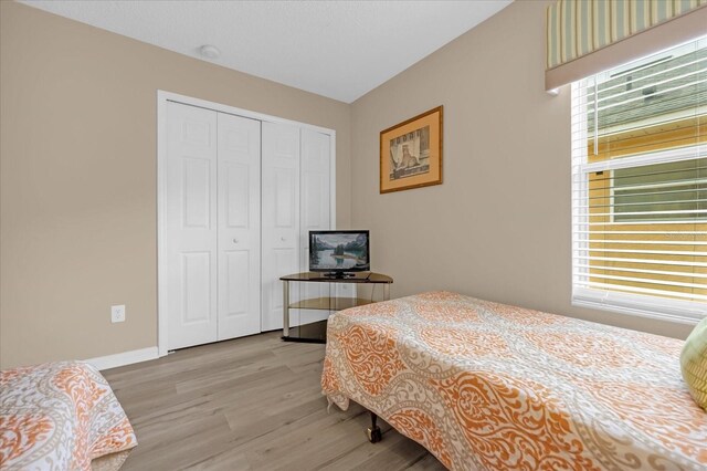 bedroom with a closet and light hardwood / wood-style flooring