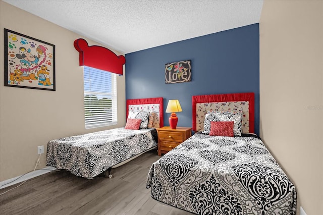 bedroom with wood-type flooring and a textured ceiling