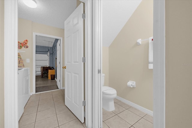 bathroom featuring toilet, a textured ceiling, and tile patterned floors