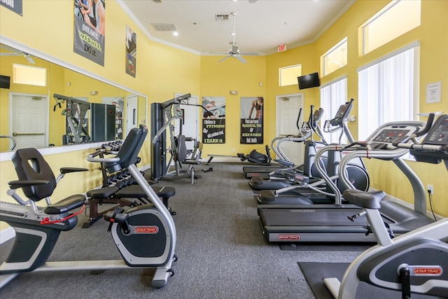 workout area featuring ceiling fan, a towering ceiling, and crown molding