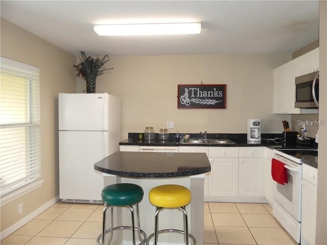 kitchen featuring white appliances, white cabinetry, a healthy amount of sunlight, and sink