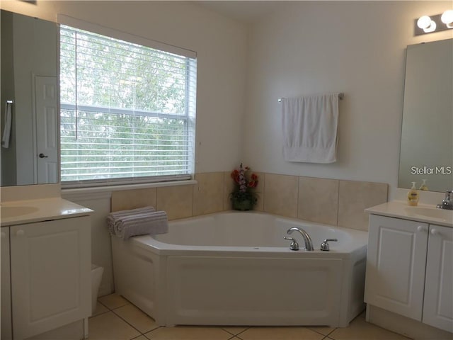 bathroom featuring tile patterned floors, vanity, and a bath