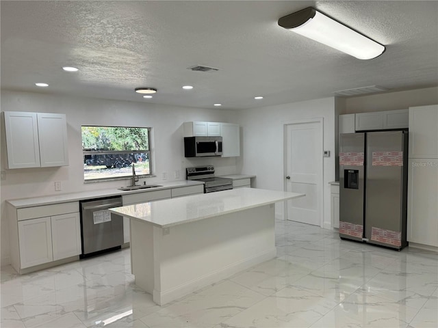 kitchen featuring white cabinets, sink, a center island, and stainless steel appliances