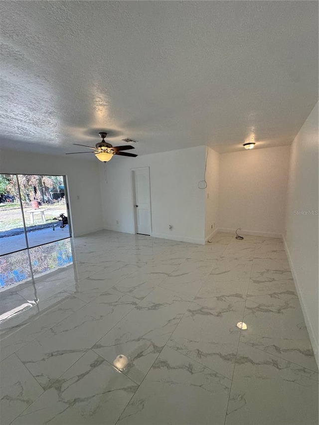 spare room with a textured ceiling and ceiling fan