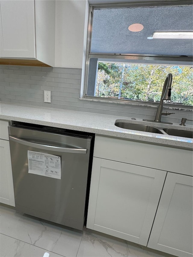 kitchen with dishwasher, marble finish floor, backsplash, and a sink