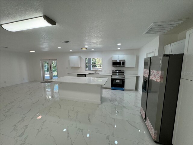 kitchen with recessed lighting, stainless steel appliances, a textured ceiling, and a sink
