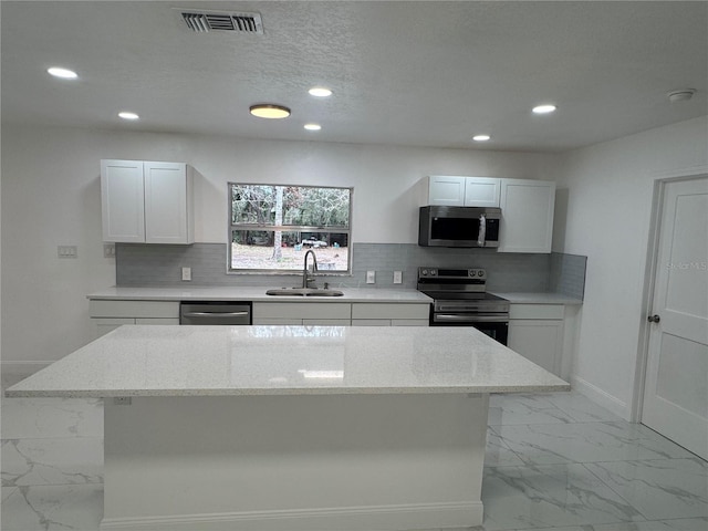 kitchen featuring marble finish floor, appliances with stainless steel finishes, a sink, and visible vents
