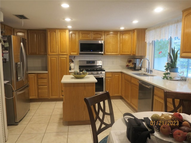 kitchen featuring sink, light tile patterned floors, tasteful backsplash, a kitchen island, and appliances with stainless steel finishes