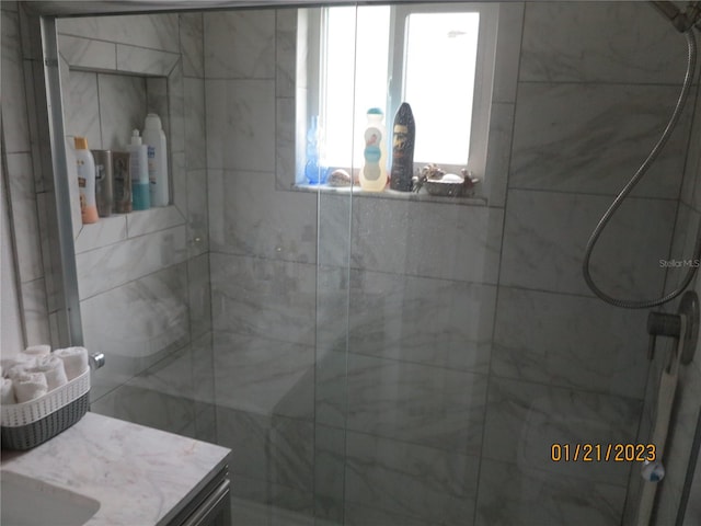 bathroom with vanity and a shower with door