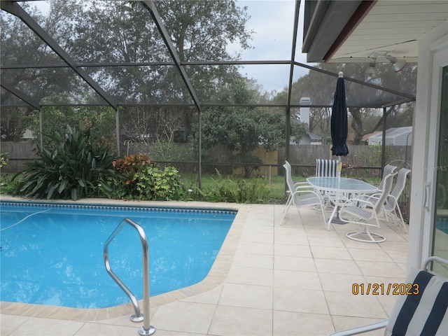 view of swimming pool featuring a patio and a lanai