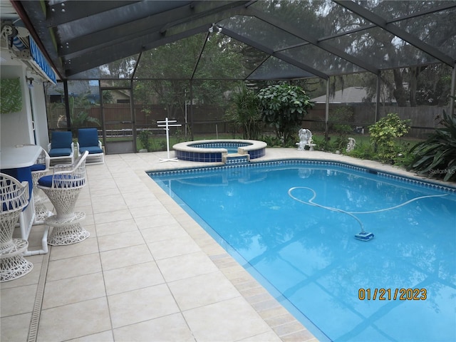 view of pool with a lanai, an in ground hot tub, and a patio