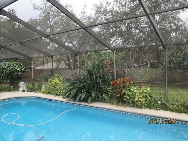 view of swimming pool featuring a lanai