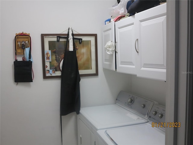 washroom with cabinets and washing machine and clothes dryer