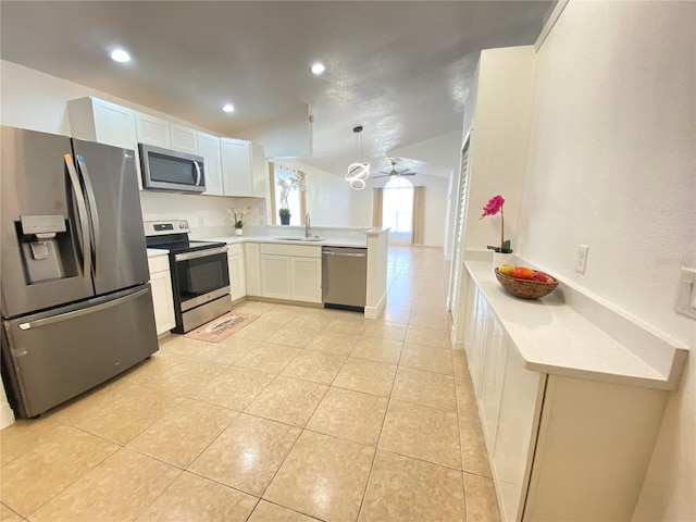 kitchen with sink, kitchen peninsula, pendant lighting, white cabinets, and appliances with stainless steel finishes