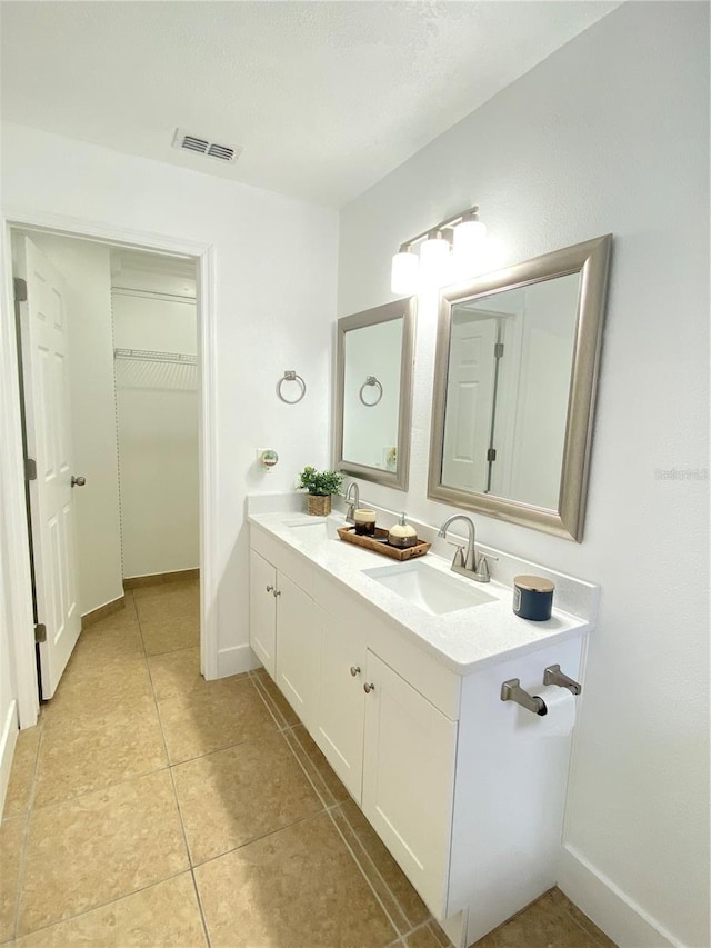 2907 Delcrest Dr, Orlando, FL 32817 - bathroom with double vanity, a spacious closet, tile patterned flooring, and baseboards