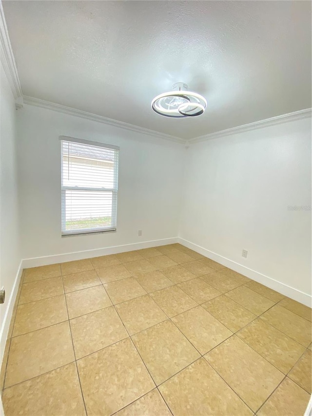 spare room featuring light tile patterned floors and ornamental molding