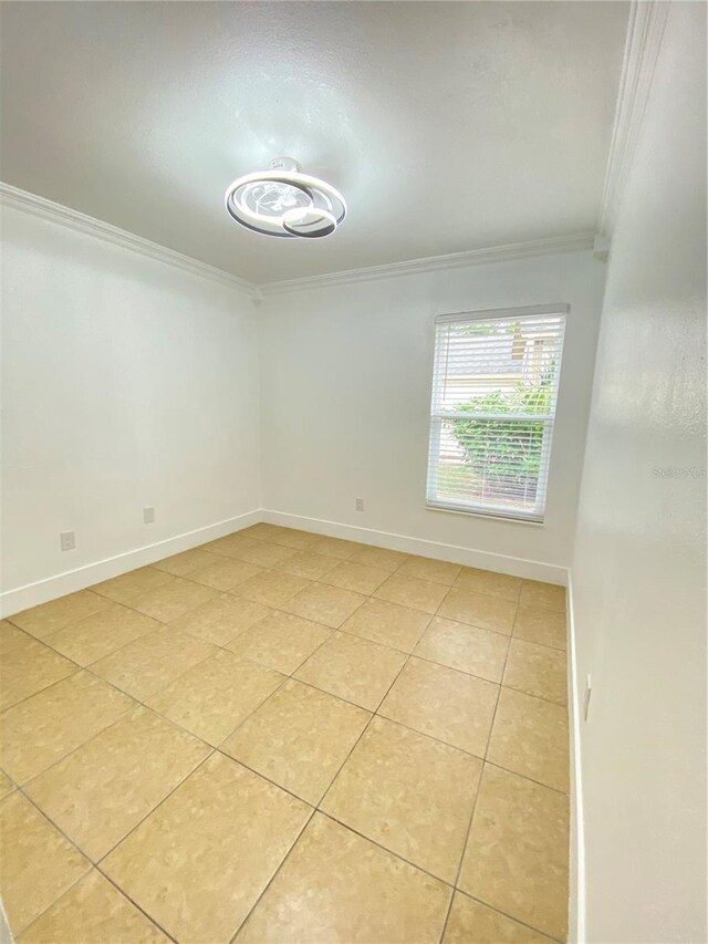 spare room with light tile patterned flooring and ornamental molding