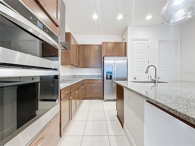 kitchen featuring light stone countertops, sink, light tile patterned flooring, and stainless steel appliances