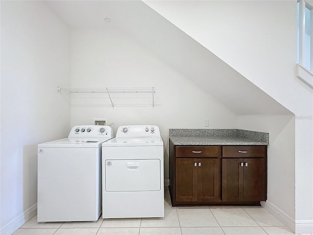 clothes washing area with washer and dryer and light tile patterned floors