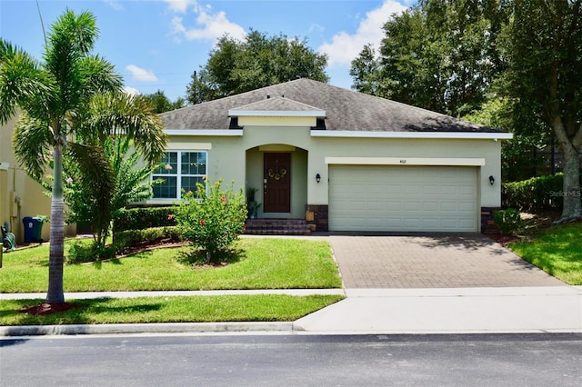 468 Andalusia Loop, Davenport, FL 33837 - view of front facade featuring stucco siding, a garage, decorative driveway, roof with shingles, and stone siding