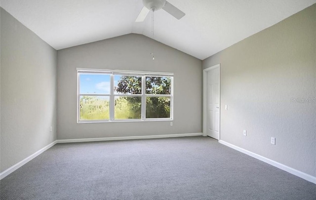 carpeted spare room featuring ceiling fan and vaulted ceiling