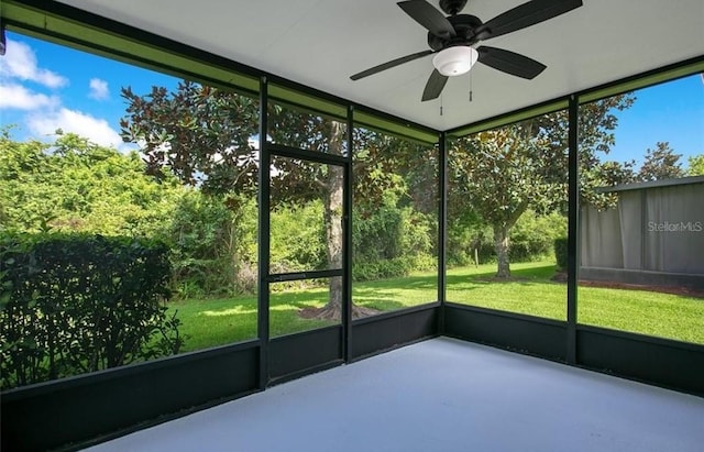 unfurnished sunroom with ceiling fan