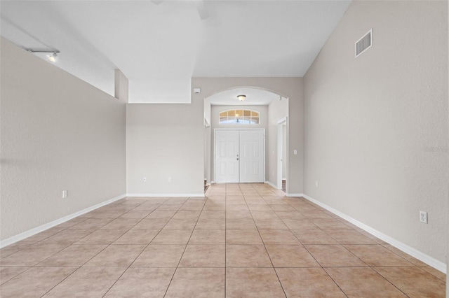 tiled foyer entrance featuring vaulted ceiling