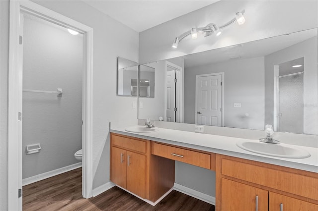 bathroom featuring vanity, wood-type flooring, an enclosed shower, and toilet