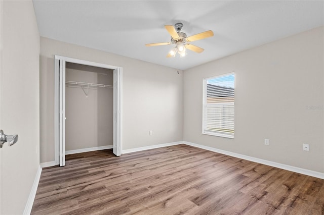 unfurnished bedroom with a closet, hardwood / wood-style flooring, and ceiling fan