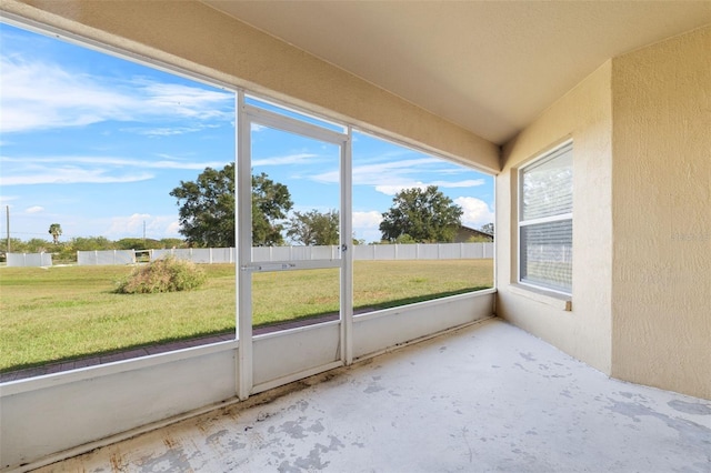 unfurnished sunroom featuring a healthy amount of sunlight and vaulted ceiling