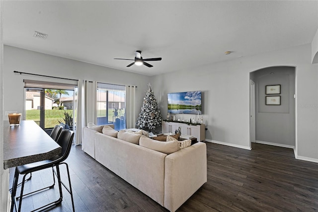 living room with ceiling fan and dark wood-type flooring