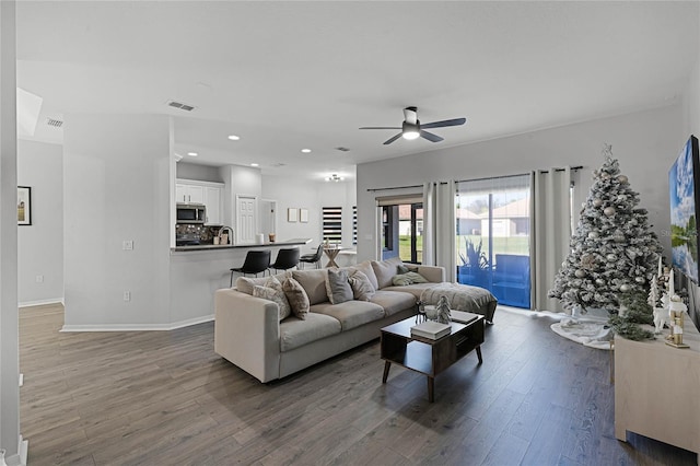 living room featuring dark hardwood / wood-style floors, ceiling fan, and sink