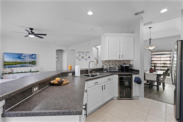 kitchen featuring stainless steel fridge, sink, white cabinets, light hardwood / wood-style floors, and wine cooler