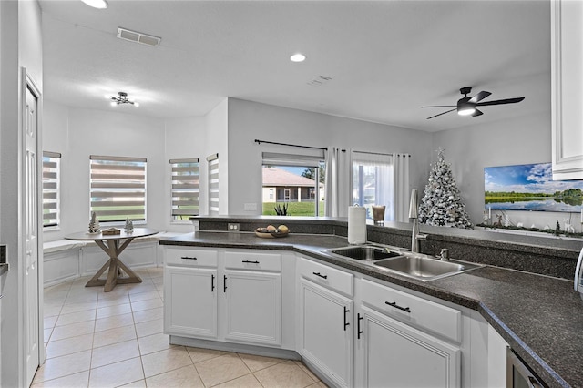 kitchen with radiator, white cabinetry, sink, ceiling fan, and light tile patterned flooring