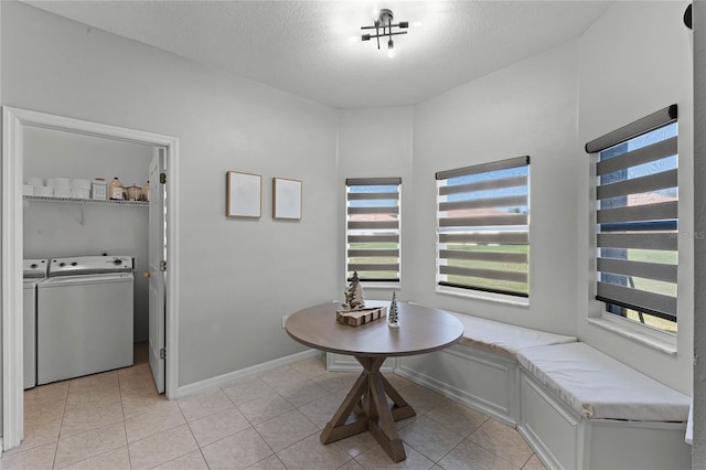 interior space featuring a textured ceiling, breakfast area, light tile patterned floors, and washer and clothes dryer