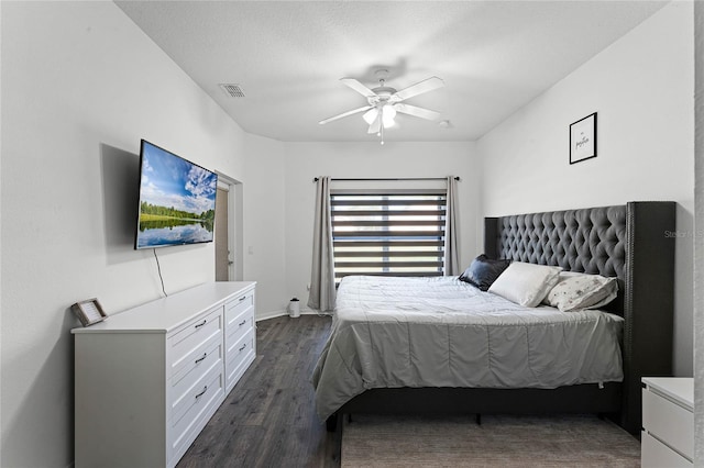 bedroom featuring a textured ceiling, dark hardwood / wood-style floors, and ceiling fan