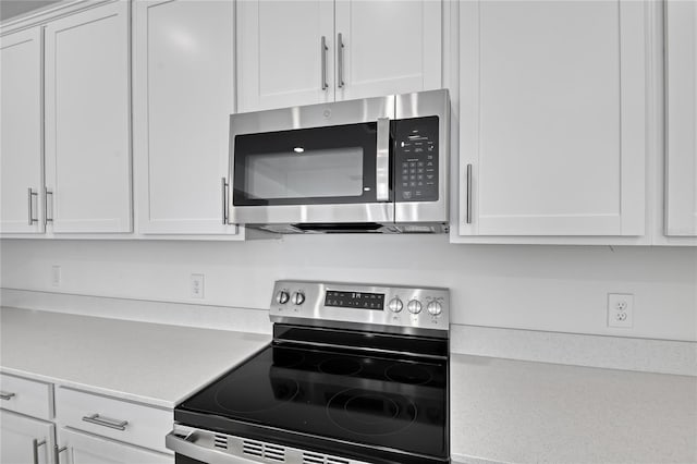 kitchen with appliances with stainless steel finishes and white cabinets