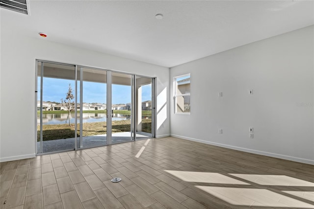 empty room with a water view and light hardwood / wood-style flooring