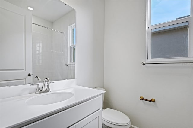 bathroom featuring a shower, vanity, and toilet